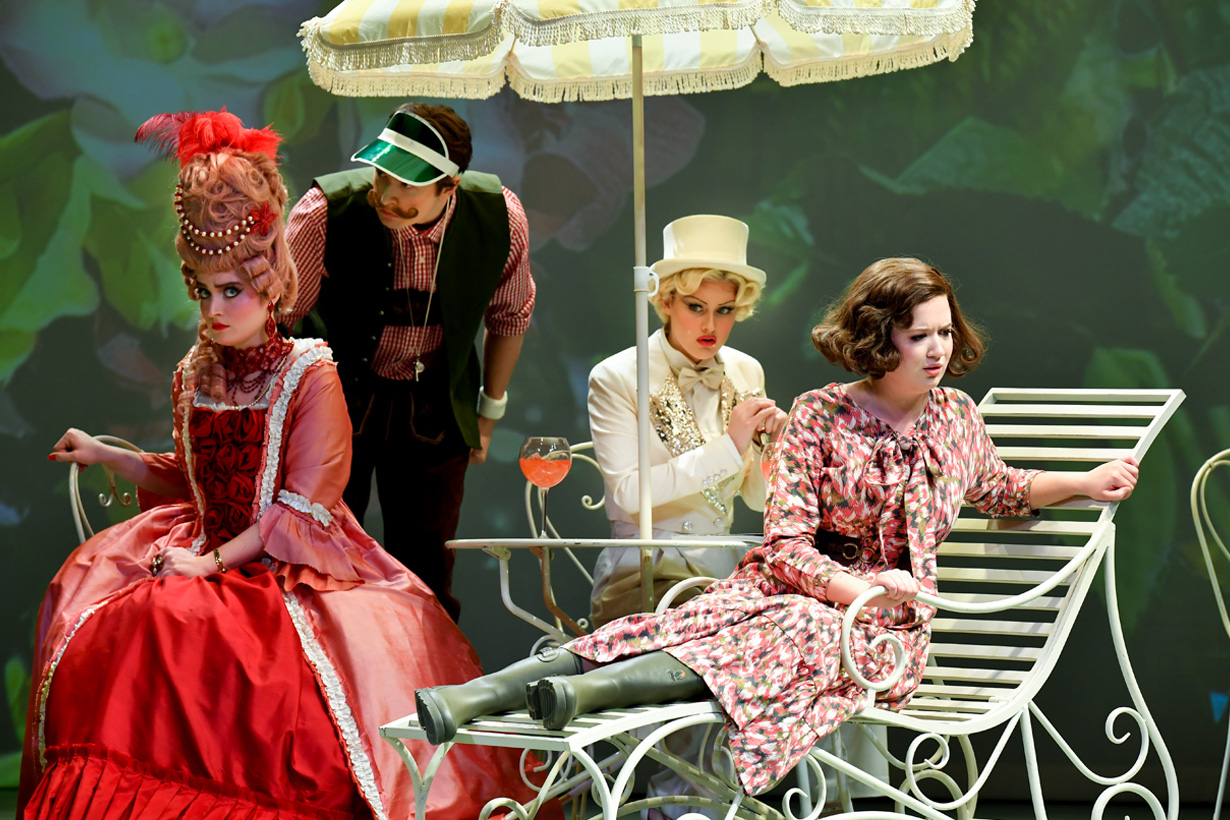 A group of students wearing costumes, performing an opera on stage.